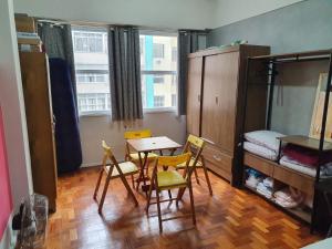 a room with a table and chairs and a bedroom at Loft Copacabana in Rio de Janeiro