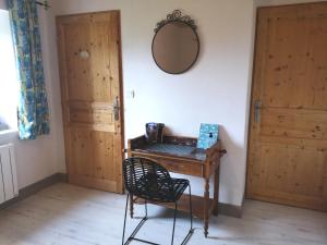 een kamer met een tafel, een spiegel en twee deuren bij Chambres et table d'hôtes Régord'âne in Le Brignon