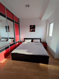 een slaapkamer met een bed en een grote spiegel bij Apartman Ana in Bosanska Gradiška