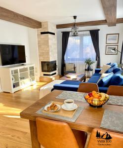ein Wohnzimmer mit einem Tisch und einem blauen Sofa in der Unterkunft Vidik B30 in Kopaonik
