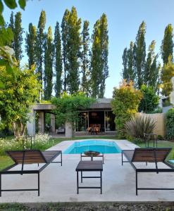 un patio con bancos y una piscina en Casa Los Cerezos en Chacras de Coria en Chacras de Coria