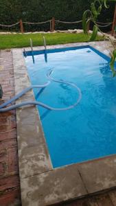 a swimming pool with a hose in a yard at Alquiler de Casa en La Falda in La Falda