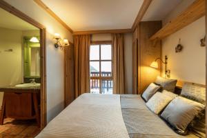 a bedroom with a bed and a sink and a window at Hameau du Glacier 524 - Arc 1950 le village in Bourg-Saint-Maurice