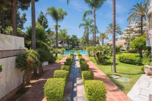 a garden with trees and a swimming pool at Puerto Banús Beach Apartments in Marbella
