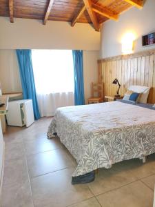 1 dormitorio con cama grande y ventana grande en Hostal El Korú en San Carlos de Bariloche
