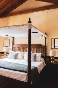 Casa rural El Hornillo في فاليهيرموسو: غرفة نوم مع سرير بأربعة أعمدة مع مظلة