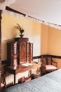 Casa rural El Hornillo في فاليهيرموسو: غرفة نوم مع مكتب خشبي وسريرين