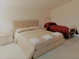 a bedroom with a large bed with towels on it at Rara Domus B&B in Pompei