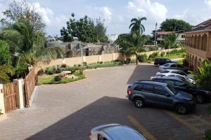 una fila de autos estacionados en un estacionamiento en Ubuntu De La Villa- Palm View Estate en Mammee Bay