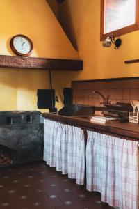 uma cozinha com um lavatório e um relógio na parede em Casa rural El Hornillo em Vallehermoso