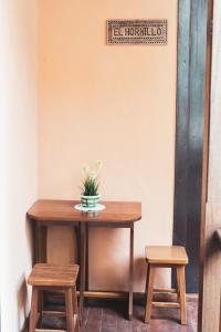 a table with two stools and a potted plant on it at Casa rural El Hornillo in Vallehermoso