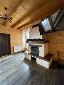 sala de estar con chimenea y TV de pantalla plana en Панорама гір en Bukovel