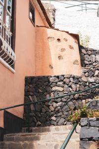 a stone wall next to a building with stairs at Casa rural El Hornillo in Vallehermoso