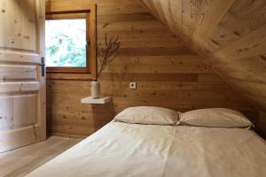 a bed in a wooden room with a window at Kostovac Boutique Homes - House 1 in Kopaonik