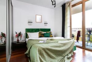 a bedroom with a large bed with a green blanket at Otium Old Town Angel Plaza in Krakow