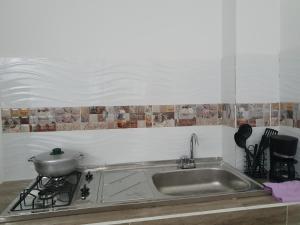 a kitchen with a sink and a pot on a stove at Apartamento Turistico Luna del Mar in San Andrés