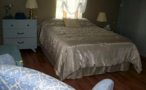 um quarto com uma cama, uma cómoda e uma janela em La Belle Époque em La Malbaie