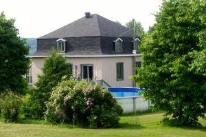 una casa con piscina frente a ella en La Belle Époque, en La Malbaie