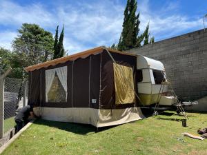 Ein Mann baut ein Zelt in einem Hof. in der Unterkunft Trailer, Esporte e Amigos in Atibaia