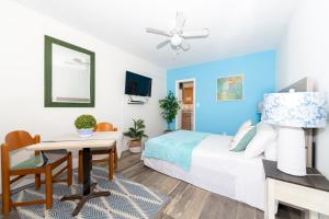 a bedroom with blue walls and a bed and a desk at Tropic Isle Hotel & Apartment in Hollywood