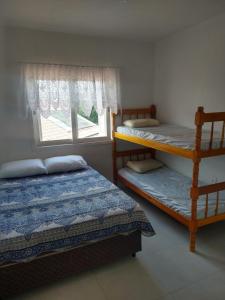 a bedroom with two bunk beds and a window at Apartamento BLUE 04 - 100 metros da praia in São Lourenço do Sul