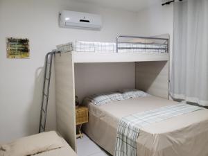 a bedroom with two bunk beds and a window at Chaleville Coqueiro 1001 in Luis Correia