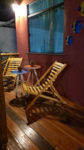 two chairs and tables in a room with a window at Chaleville Coqueiro 1001 in Luis Correia