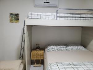 a bedroom with two bunk beds and a night stand at Chaleville Coqueiro 1001 in Luis Correia