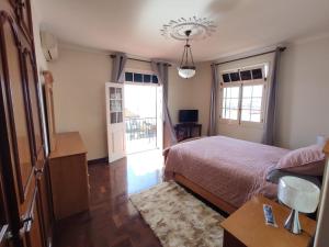 a bedroom with a bed and a window and a door at Villa Telo in Funchal