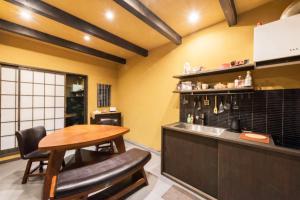 a kitchen with a wooden table in a room at Hotel Zipangu Tameikecho in Kyoto