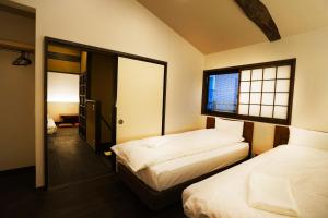 a bedroom with two beds and a window at Hotel Zipangu Tameikecho in Kyoto