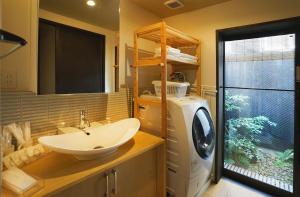 a bathroom with a sink and a washing machine at Hotel Zipangu Tameikecho in Kyoto