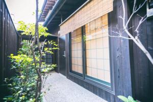 a walkway leading to a building with windows at Hotel Zipangu Tameikecho in Kyoto