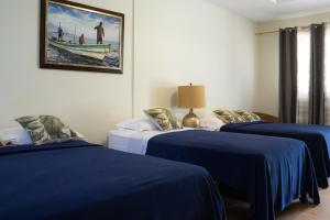 une chambre avec deux lits et une photo d'un bateau dans l'établissement Hotel Kevin, à Los Santos