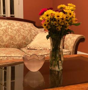 a vase of flowers on a table next to a couch at The Cottages at Capitol Park in Baton Rouge