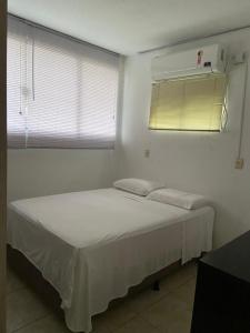 a white bedroom with a bed and a window at Casas Borges in Torres