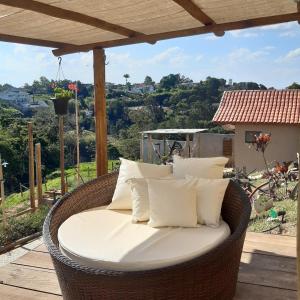 a wicker chair with white pillows on a patio at B&B Sol Poente in Cunha