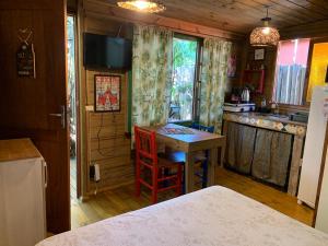 a kitchen with a small table in a room at Chale canto verde Villa Facioni in Palhoça