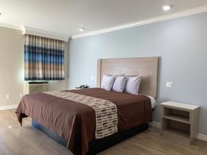 een slaapkamer met een groot bed en een raam bij Mojave Inn in Victorville