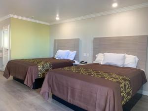 two beds sitting next to each other in a room at Mojave Inn in Victorville +29 photos