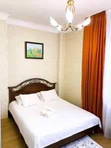1 dormitorio con 1 cama y 2 toallas blancas en Трехкомнатные апартаменты в центре Левого Берега г.Нур-султан en Astaná