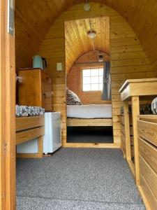 een klein huisje met een bed en een raam bij Farm Therapy 