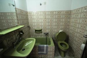 a bathroom with a green sink and a toilet at Hotel Platon in Faliraki