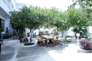 a patio with tables and chairs and trees at Hotel Platon in Faliraki