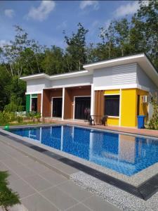 a house with a swimming pool in front of it at Laura Guest House Langkawi in Pantai Cenang
