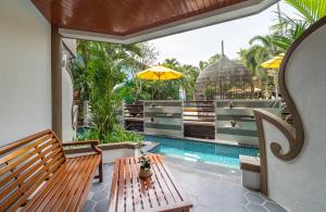 un patio con banco y piscina en Aonang Princeville Villa Resort & Spa - GHA WellHotel-Halal Certified, Krabi, Thailand, en Ao Nang Beach