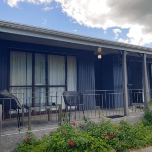 a screened in porch with two chairs and a table at Harakeke Homestay in Hastings