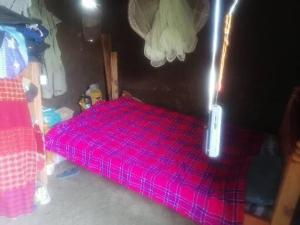 Sekenani的住宿－Maasai homestay camping，卧室配有粉红色的床。