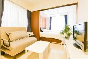 a room with a bed and a couch and a tv at Northwest IR Room 201 - Vacation STAY 8477 in Sapporo