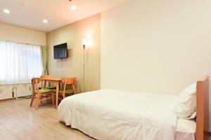 a hotel room with a bed and a table and chairs at Heights N7 / Vacation STAY 7569 in Sapporo